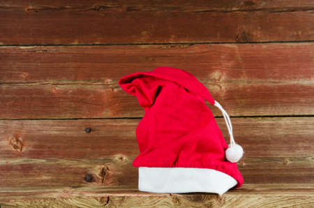 Santas cap laid at an old weathered wooden barn wallの写真素材