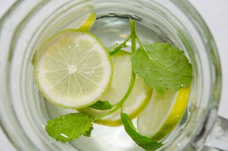 Fresh water with lemon slices and mint leaves in a pitch from aboveの写真素材