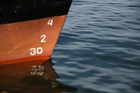 Numbers and reflections of a bow of a ship in waterの写真素材