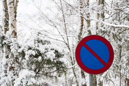 No parking roadsign in a forest with snow all over
