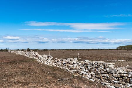 Boundry of a traditional dry stonewall in a great grassland Stora Alvaret on the island Oland in Swedenの写真素材