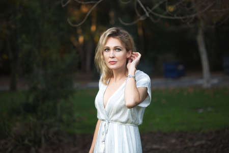 one along womann in the white dress in dark parkの写真素材