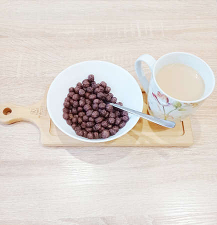 Dry breakfast in a plate and coffee with milk. Chocolate balls for breakfast