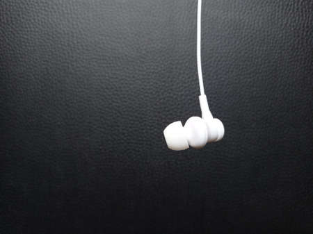 Earphone on black leather backgroundの写真素材
