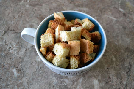 Croutons in a bowl, dried white bread squares in a cupの写真素材