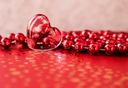 Shining transparent heart and a group of red beads. Perfect Valentine's Day greeting card background.の写真素材