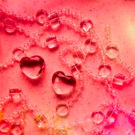 Transparent hearts and beads on marble in pink tone. Perfect Valentine's Day greeting card background.の写真素材