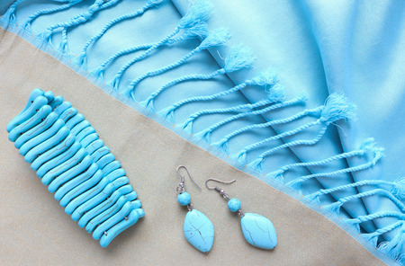 Turquoise bracelet and earrings from natural stone on fringed scarfの写真素材