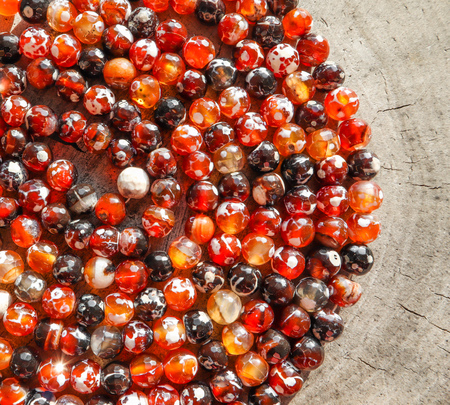 Beads of amber fireplace faceted agate on rough surface of an old stump