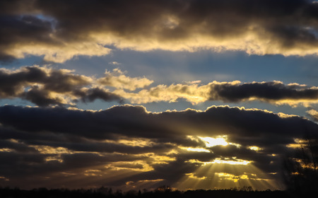 Blue sky and dark clouds with sunlightの写真素材