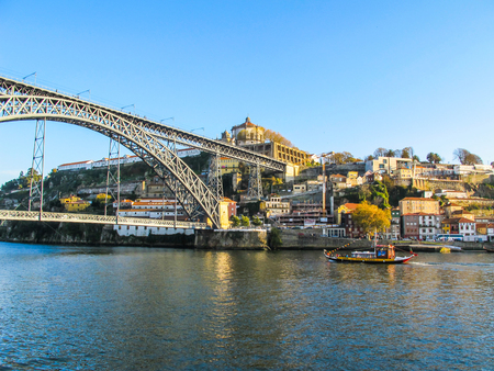 Porto / Portugal - November 27 2010: Panorama of the city, metallic Dom Luis bridge over Douro river and  tourist Rabelo Boatの写真素材