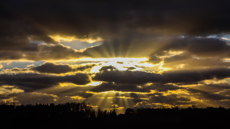 Blue sky and dark clouds with sunlightの写真素材