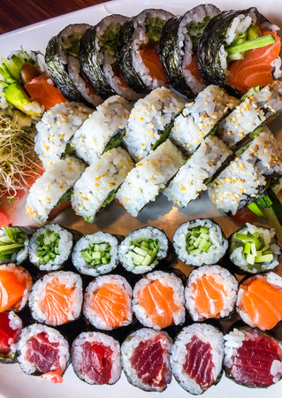 Variety of japanese sushi rolls on a white plateの写真素材