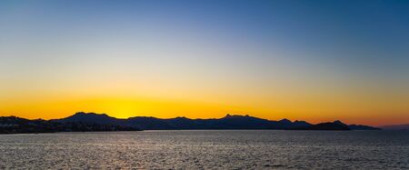 Beautiful bright colorful sunset on the Mediterranean Sea with islands, mountains and boatsの写真素材