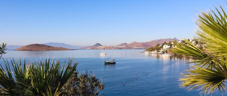 Aegean coast with marvelous blue water, rich nature, islands, mountains and small white housesの写真素材