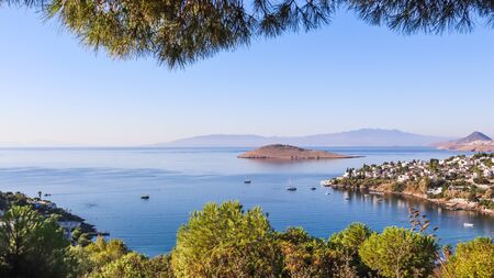 Aegean coast with marvelous blue water, rich nature, islands, mountains and small white housesの写真素材