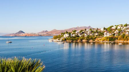 Aegean coast with marvelous blue water, rich nature, islands, mountains and small white housesの写真素材