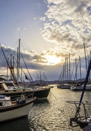 Nature, twilight, holiday destination and travel concept - Summer sunset at the Mediterranean sea coast, luxury yachts in marina and mountain viewの写真素材