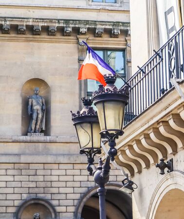 Architectural details of building facades in Paris with French flagの写真素材