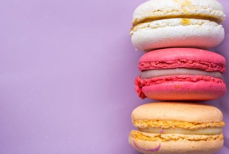 Colorful french cookies macarons set on pink background. Tasty fruit, almond sweet cookies, cake macaron. Holiday backdrop design.の写真素材