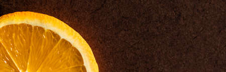Part of an orange slice on a dark background. Place for your textの写真素材
