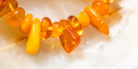 Solar beads of fiery amber on onyx marble background. Natural stone backdrop.の写真素材