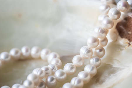Nature white string of pearls on marble background in soft focus, with highlights.の写真素材