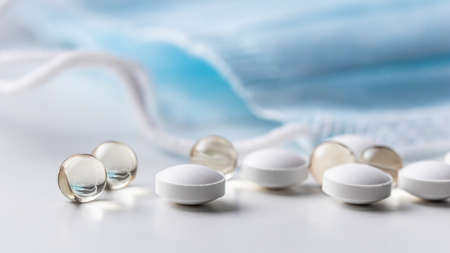 Capsules, pills and medical masks on a white background. Health care, medical, pharmacy and illness conceptの写真素材