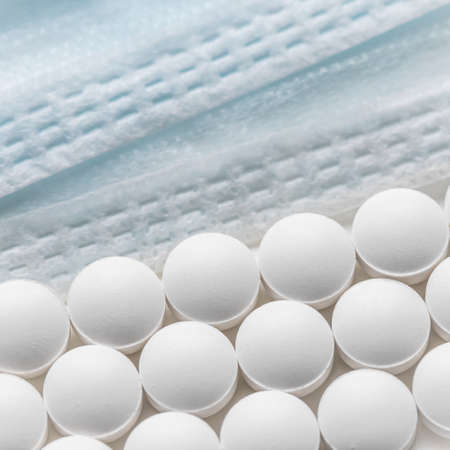 Rows of pills and medical masks on a white background. Health care, medicine, pharmacy and disease conceptの写真素材