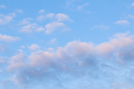 Blue sky background with white and pink clouds at sunsetの写真素材