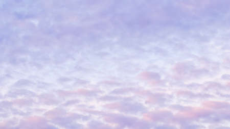Background of blue sky with pale pink clouds in sunset