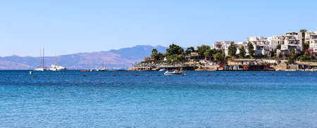Blue sea, boats, mountains and small town on the coast of the Aegean sea. Summer holidays and coastal nature conceptの写真素材