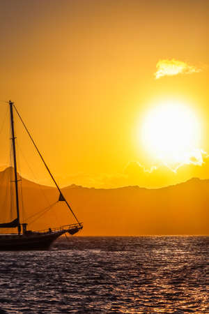 Beautiful sunset on the Aegean Sea with mountains and a sailboat. Seascape, travel and nature concept. High quality photoの写真素材