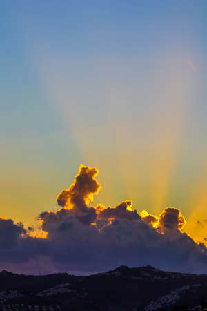 Background from a beautiful sunset with clouds and sunlights over mountanous coast. High quality...