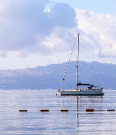 Blue sea, a boat and mountains in sunrise. Tranquil seascape and coastal nature conceptの写真素材