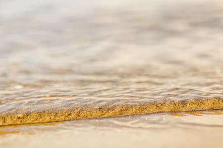 Flowing wave on the sea sandy beach. Summer vacation backgroundの写真素材