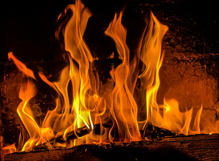Flames of fire on a black background. Burning wood in the fireplaceの写真素材