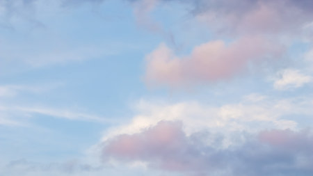 Background of blue sky with pale pink clouds at sunsetの写真素材
