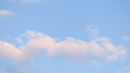 Background of blue sky with pale pink clouds at sunsetの写真素材