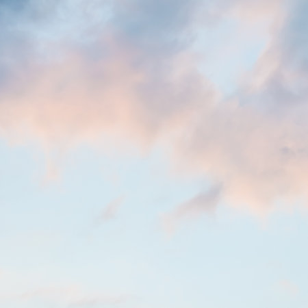 Background of blue sky with pale pink clouds at sunset
