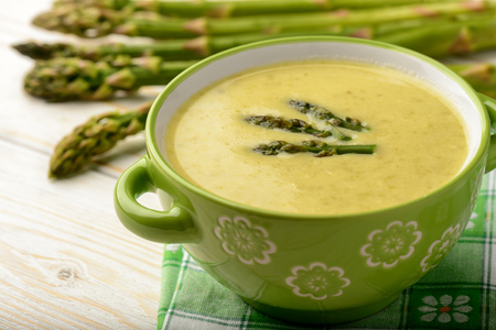 Green asparagus cream soup on wooden background.の写真素材