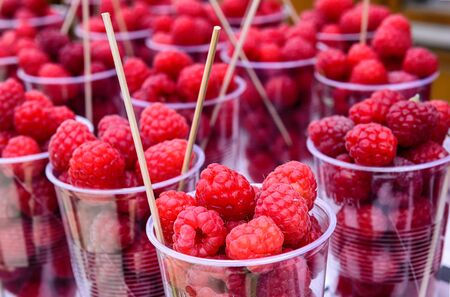 Raspberries sold in plastic cups on the street markets.の写真素材