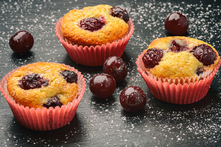 Cherry muffins on black background.の写真素材
