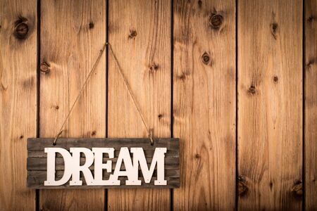 Wooden sign DREAM on wooden background.の写真素材