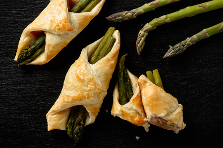 Asparagus baked in puff pastry with ham and cheese.の写真素材
