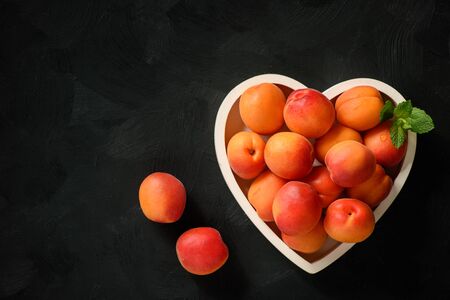 Ripe apricots on a wooden tray.の写真素材