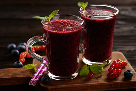 Healthy beverage - blueberry smoothie on a wooden background.の写真素材
