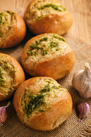 Homemade garlic bread rolls on a wooden background.の写真素材