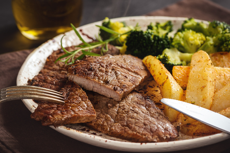 Grilled beefsteack with broccoli and baked potatoes.の写真素材
