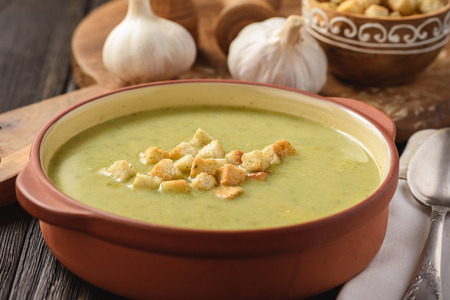 Broccoli cream soup with croutons on a wooden background.の写真素材